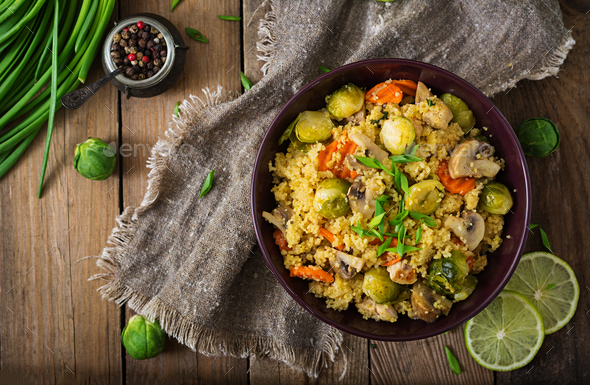 Vegetarian couscous salad with brussels sprouts, mushrooms, carrots and spices. Fitness food. - Stock Photo - Images