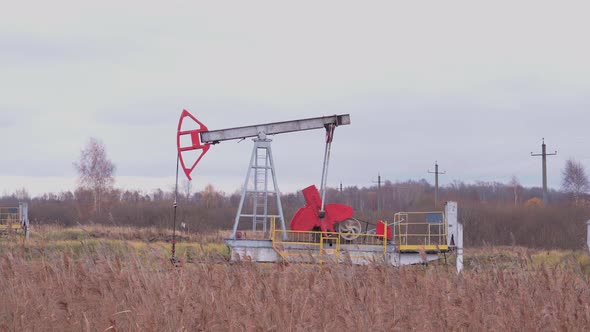 One oil pump works in the field in the autumn. Oil production in Russia alt