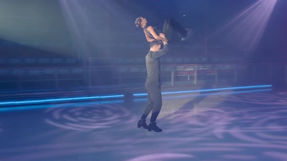 Figure Skater Moving Backwards Lifts Female Partner By Waist Makes Throw Helping to Make Back Flip