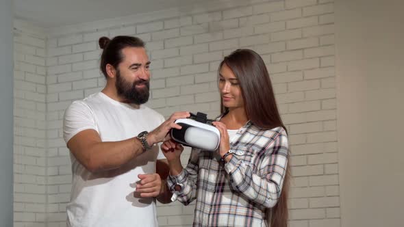 Handsome Bearded Man Watching His Girlfriend Using Virtual Reality Glasses alt