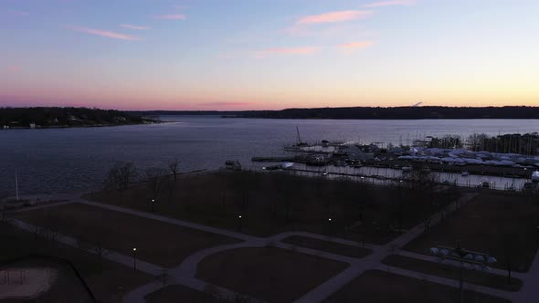 an aerial shot over an empty park focused on the bay during a beautiful sunrise. It is golden hour a alt