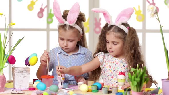 Happy Children Wearing Bunny Ears Painting Eggs on Easter Day