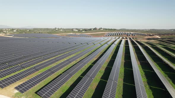 Solar panels set at optimal angle on solar farm; slow aerial pan