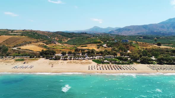Establishing Aerial View of Crete Island in Greece with Sea and Beach Umbrellas