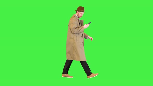 Professional Detective Dressed in Retro Coat Walk Holding Smartphone Browsing or Reading Message on