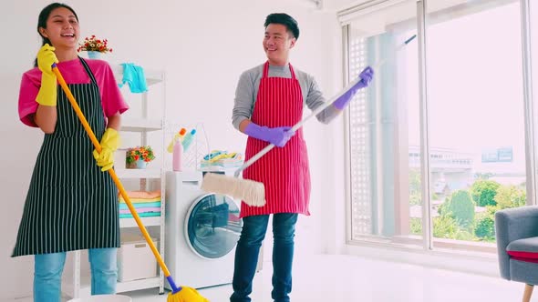 Husband and wife having fun while cleaning their room. alt