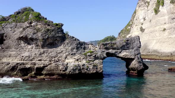 Atuh Beach natural arch in Nusa Penida island, Aerial approach shot alt