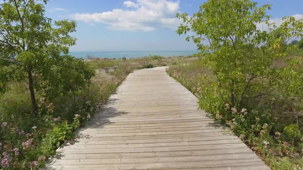 walking down boardwalk trail at the beach 4k gimbal alt