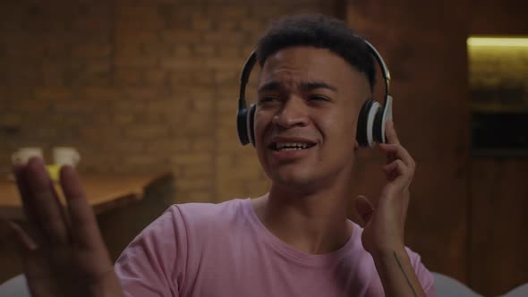 Millennial African American Man Singing Song Emotional and Dancing with Hands at Home alt