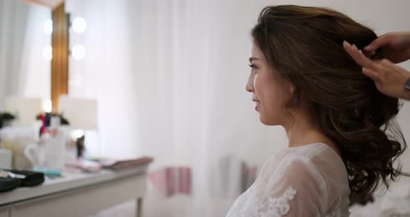 Hairdresser creating a hairstyle for female model in salon alt