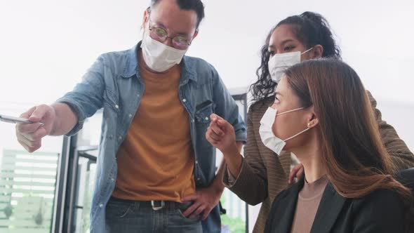 Asian young business people group wear face mask, have discussion meeting and brainstorm in office alt