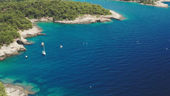 Touristic Watercraft Drift on Azure Sea Near Rocky Beach alt