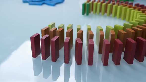 Line up of Dominoes in Rainbow Falling Colors with LGBT Colors of a Hand alt