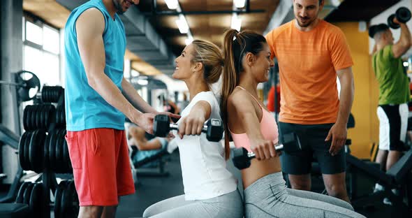 Two Attractive Women Exercising with Personal Trainers alt