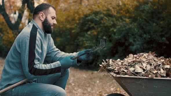 Garden Worked Who Is a Man Removing and Cleaning the Dry Leaves From the Rake alt