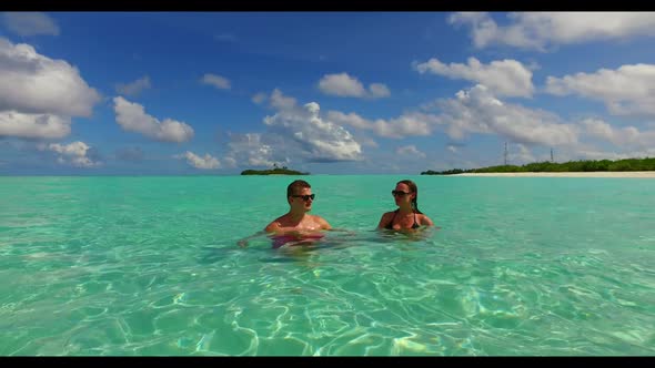 Guy and girl sunbathe on beautiful shore beach voyage by blue green ocean and white sandy background alt