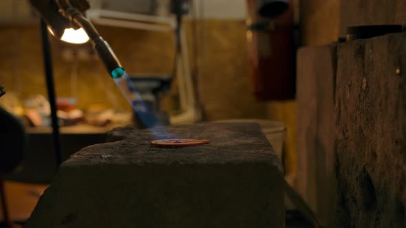 The Craftsman Works with the Part Using a Gas Burner at High Temperatures alt