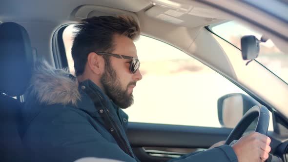 Male Driver Turning Steering Wheel In Car. Man Driving Auto And Using Controls In Car. alt