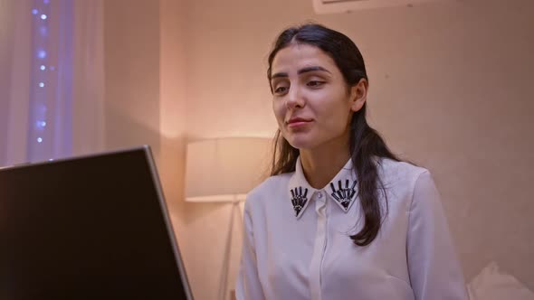 Happy Indian Young Woman Communicating By Conference Call Speak Looking at Computer at Home Office