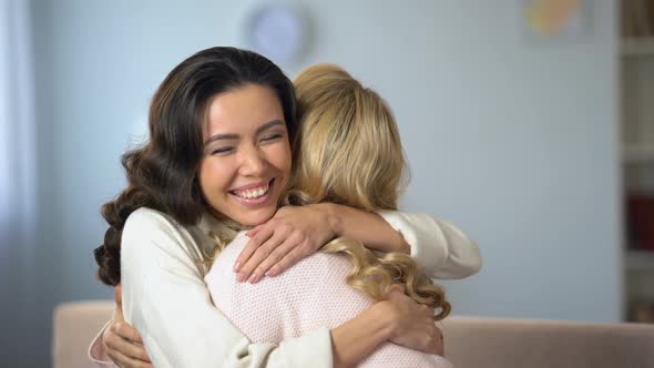 Two Young Women Hugging and Sincerely Smiling, True Old Friendship, Indoors alt