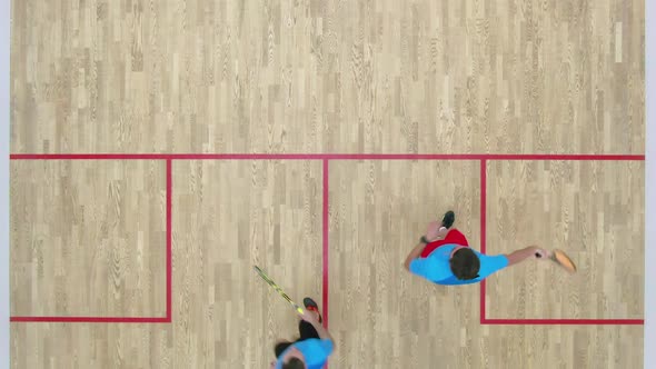 Top View of Two Men Competing in Squash in Gym. Adult Caucasian Sportsmen Playing Sport Game Indoors alt