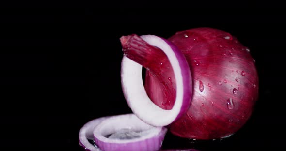 Rings of Red Onion Falling on the Water with a Splash.  alt