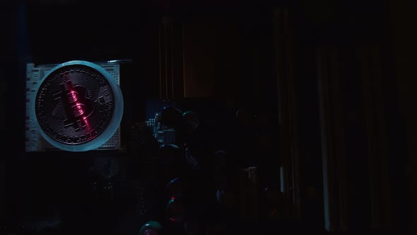 A bitcoin on a dark background is illuminated with a contrasting light and scanned by a red laser alt