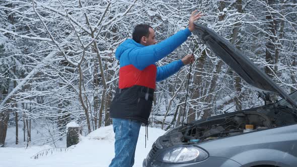 Disappointed Young Man Opening Bonnet of Broke Down Car To Check Engine