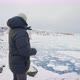 Man In Winter Coat Looking Over Town Of Ilulissat - VideoHive Item for Sale