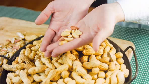 The Woman Analyzes the Quality of Peanuts with Bark alt