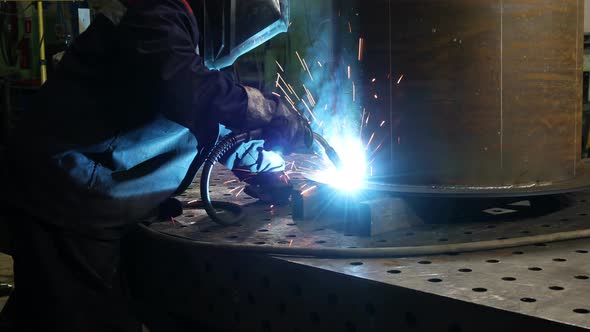 Metalworker in Safety Mask And Gloves Using Welding Torch to Join Sides of Metal Construction
