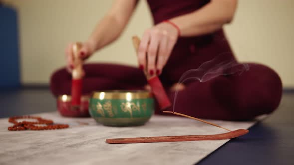 Unfocused Footage of Scented Stick Mouldering While Female Hands are Clattering on Something alt