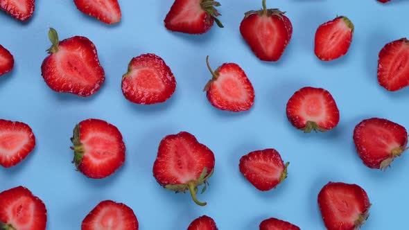Rotating Strawberry Cut in Half on a Blue Background Strawberry Texture or Trendy Summer Fruit