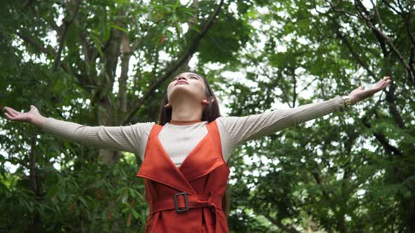 Beautiful Young Woman standing with arms raised enjoy in nature alt