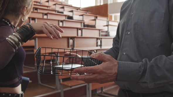 Professor Holding Basket where Students Put their Smartphones alt