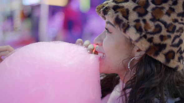 Face of Cute Young Female Biting Sticky Pink Colour Candy Floss in Funfair Park alt