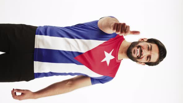 Fulllength Vertical Shot of a Happy Young Latin American Man in a Tshirt with Cuba's Flag alt