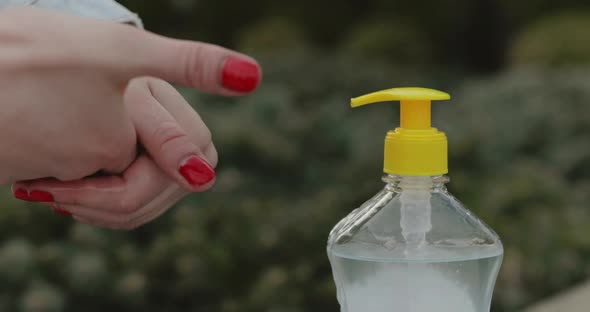 Close View of Female Hands Pushes Sanitizer and Disinfectants Hand alt