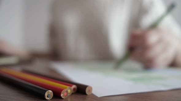 Blurred of Girl Draws with Pencils alt