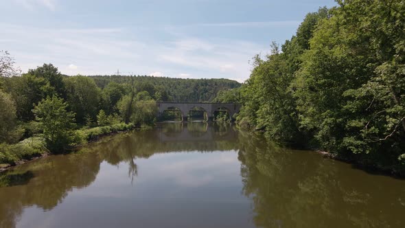 Old brick train trestle leading over the Sieg river near Schladern, Germany on a sunny spring day. L alt