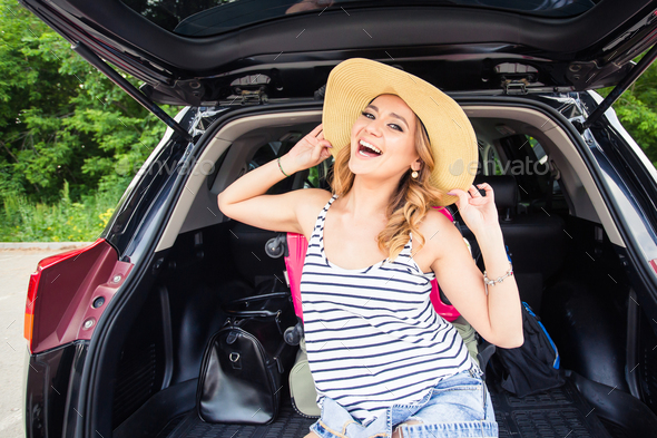 Happy woman cheering joyful during holiday travel with car