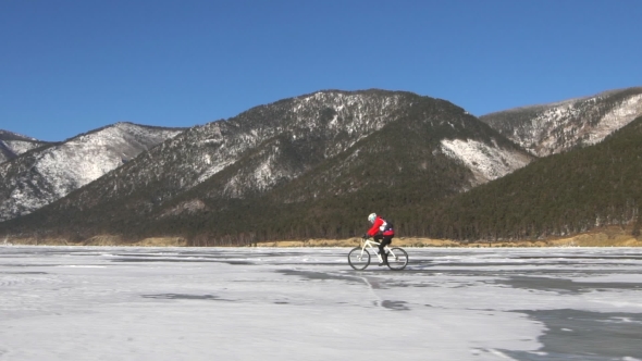 Men Riding a Bicycle on the Surface of Frozen Lake