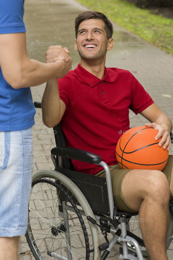Happy disabled man holding a basketball