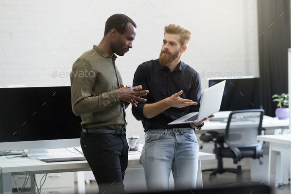 Two business men working together on laptop