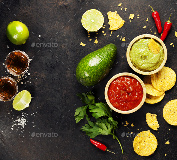 Green Homemade Guacamole with Tortilla Chips, Salsa and tequila - Stock Photo - Images