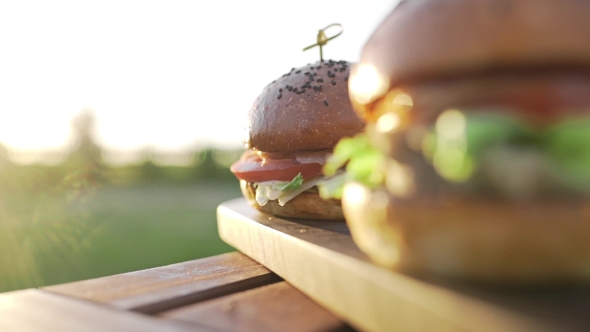 VideoHive Hot Burgers on the Wooden Board in the Sunset Sunlight at the Coutriside Fast Food Meals Cooking 20314812 VideoHive Hot Burgers on the Wooden Board in the Sunset Sunlight at the Coutriside Fast Food Meals Cooking 20314812