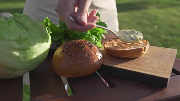VideoHive The Cook Puts Sauce To the Bun and Makes Burger Outside Countryside Cooking Open Air Cooking Meal 20314827 VideoHive The Cook Puts Sauce To the Bun and Makes Burger Outside Countryside Cooking Open Air Cooking Meal 20314827