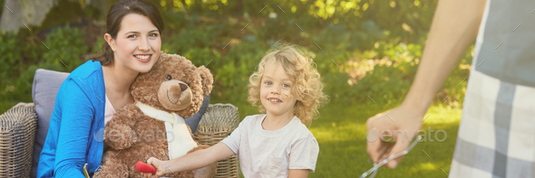 Boy and woman with teddy bear in the garden