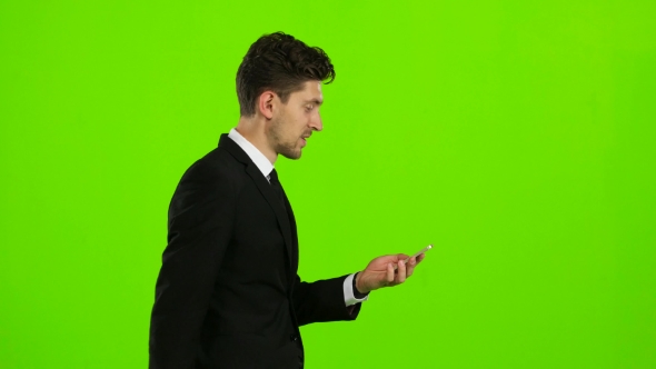 Guy Looks at the Photo on the Phone and Finds a List of Pictures,. Green Screen alt