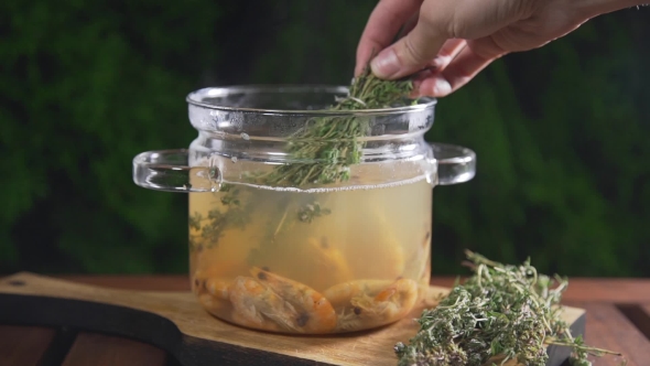 VideoHive The Cook Puts Bunch of Thyme To the Hot Shrimp Broth in the Glass Pan Standing on the Wooden Board 20320860 VideoHive The Cook Puts Bunch of Thyme To the Hot Shrimp Broth in the Glass Pan Standing on the Wooden Board 20320860
